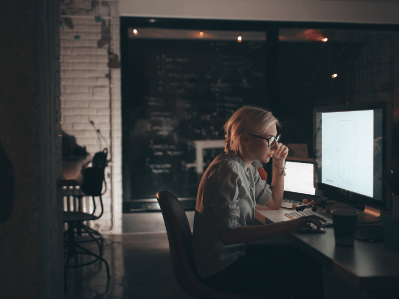 woman working shift job and staring at laptop late at night, risk factor of insomnia