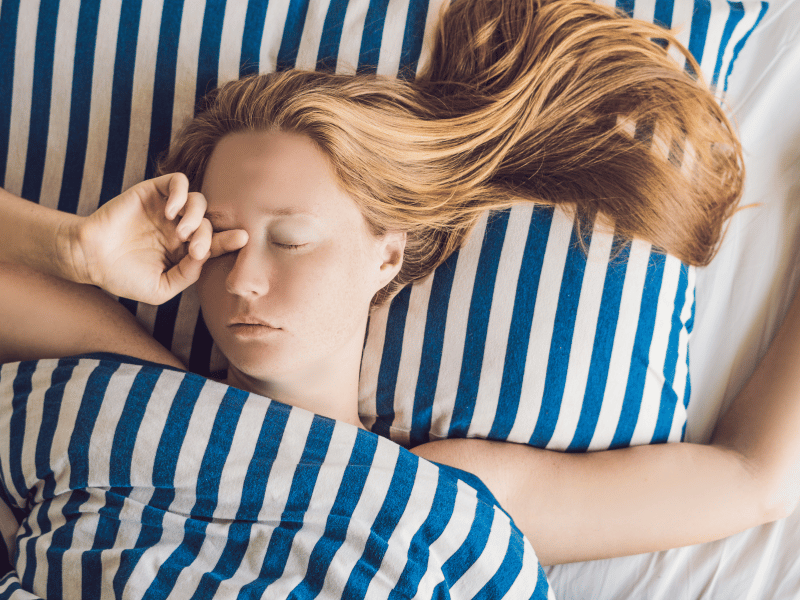 woman in bed rubbing eyes, get enough sleep for reducing anxiety