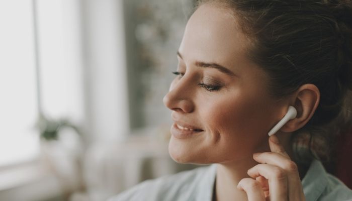 women smiling wearing earbud