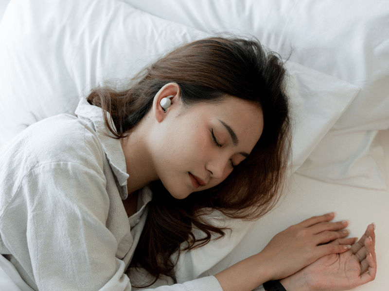 woman sleeping with earbuds on