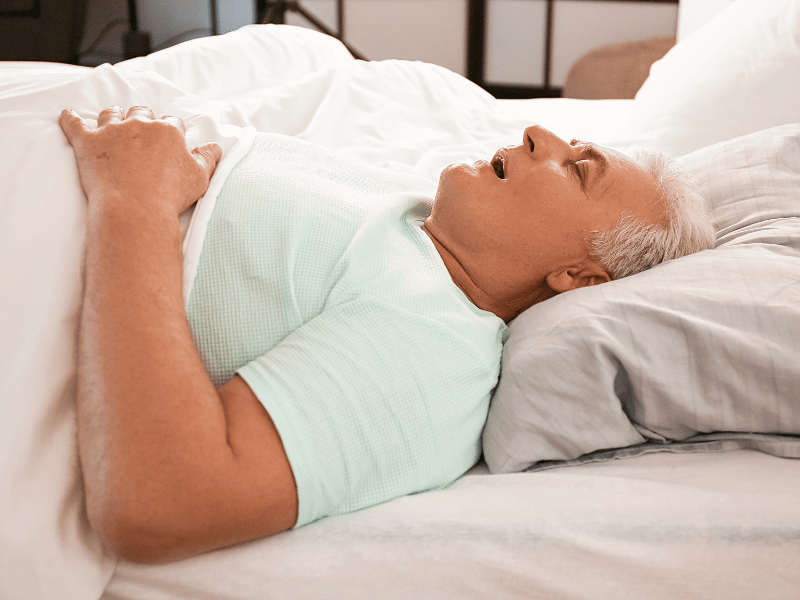 man sleeping and breathing with mouth open which is a possible sign of sleep apnea that can be detected by recording sleep