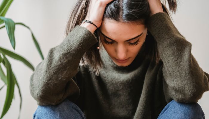 woman holding head in frustration