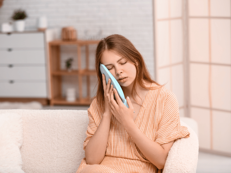 woman applying cold compress to her face