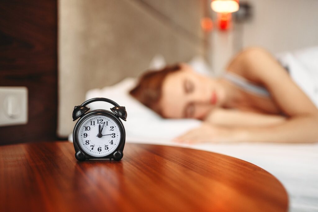 women sleeping beside a numeral alarm clock