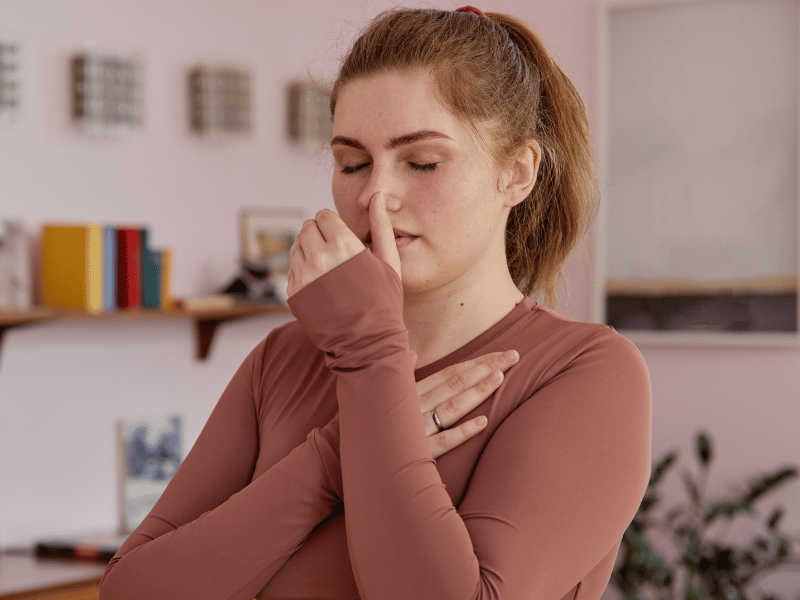 woman doing alternate nostril breathing exercise for stress relief to fall asleep