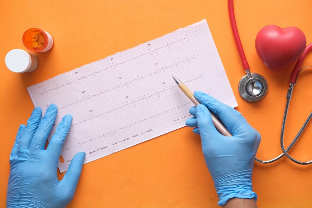 person writing on white ECG paper

