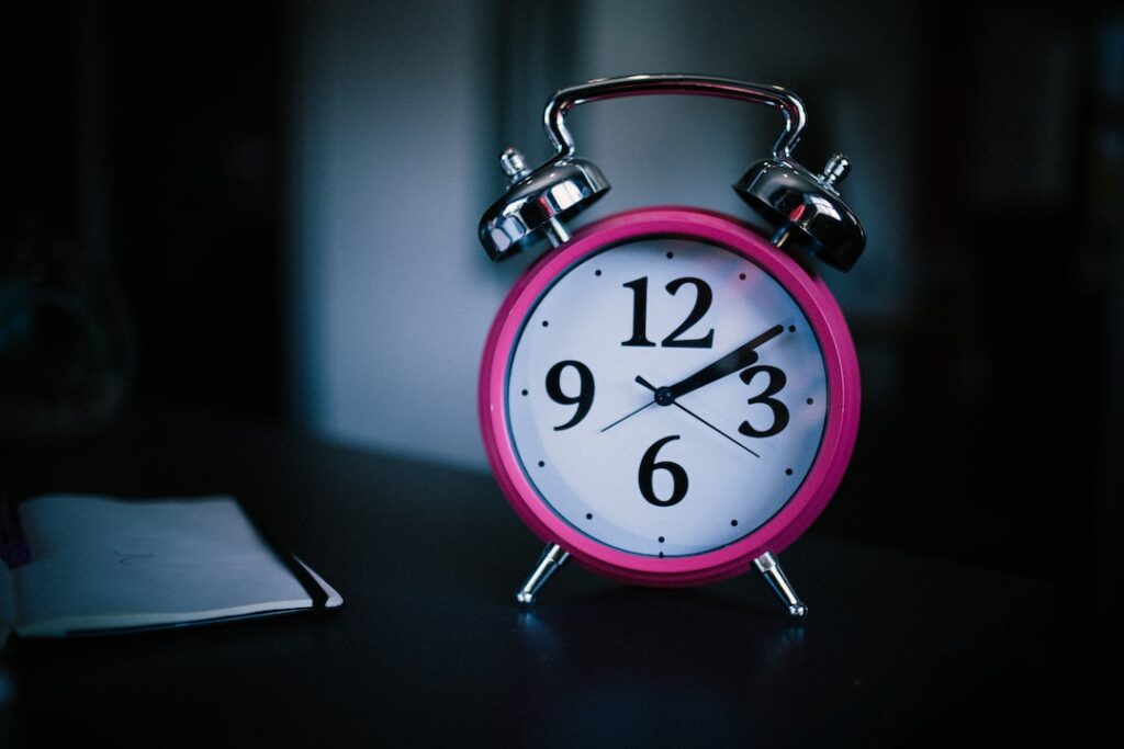 pink alarm clock showing 2:10 time