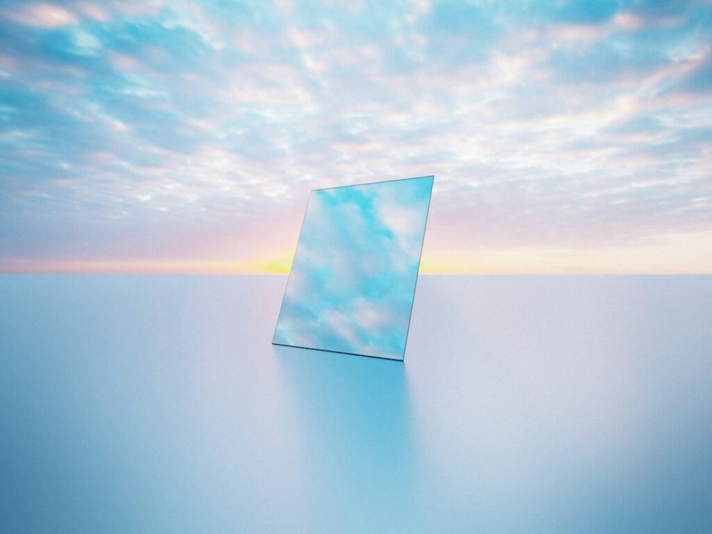 a mirror sitting on top of a table under a cloudy sky
