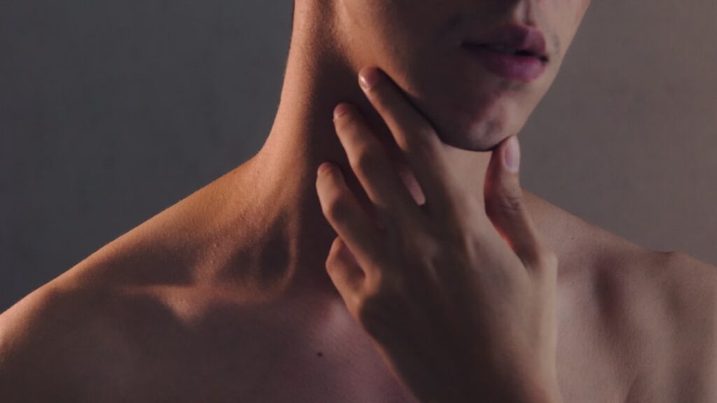 male person holding neck