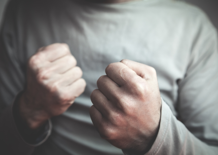 person showing clenched fist in a fight stance