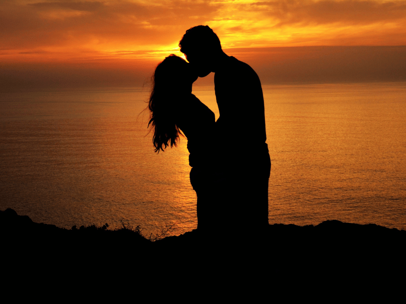 silhouette of a couple kissing with a background of the sun setting, dream of kissing someone