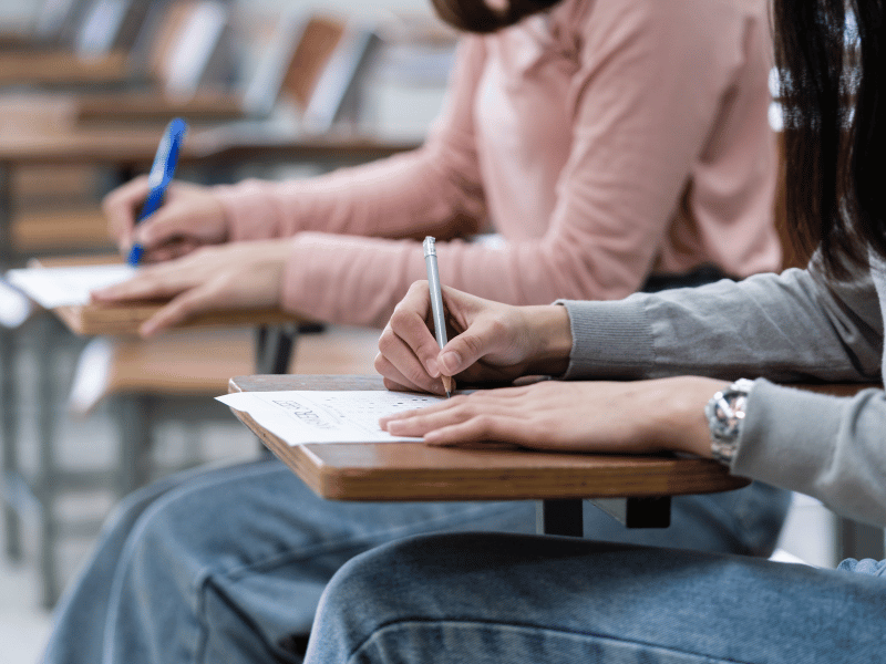 hand holding onto a pencil and using it to fill an exam sheet - taking an exam in dreams