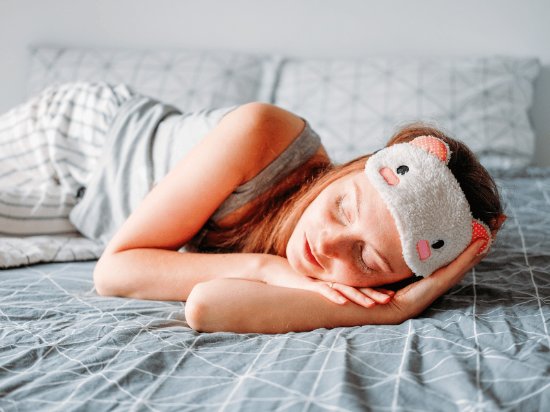 woman with eye mask around her forehead and sleeping on the bed, forming good sleep habits which is an alternative to sleeping pills