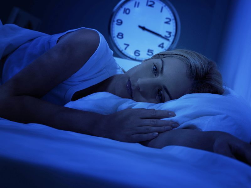 woman lying on bed with insomnia sleep problem can benefit from taking melatonin