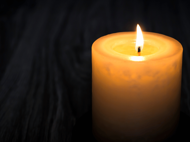 candle lit in the dark a symbol of holding a vigil for someone's death