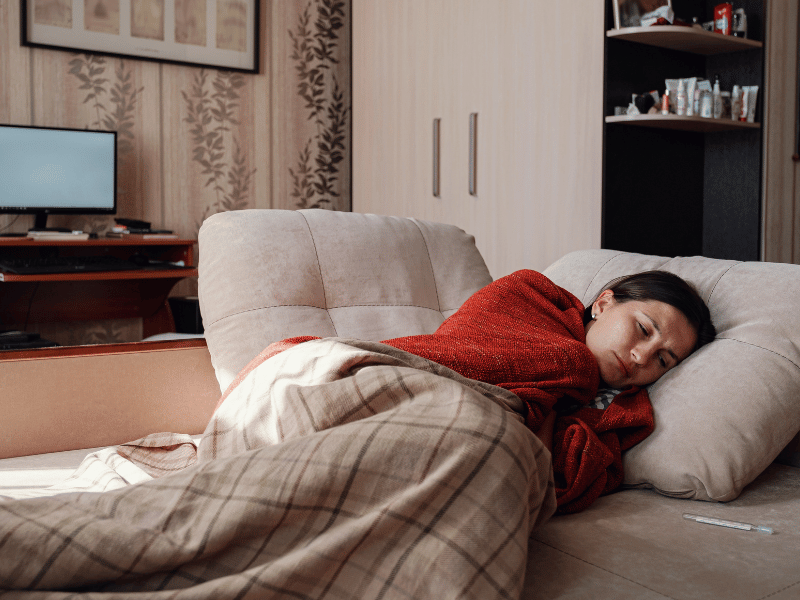 woman resting in bed, feeling sick from a cold