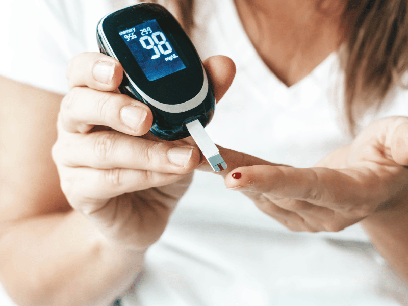 A woman uses a blood glucose meter to monitor her blood sugar levels effectively.