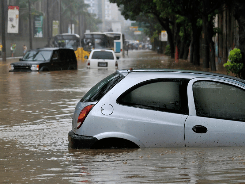 a grey car shown partially submerged in flood waters