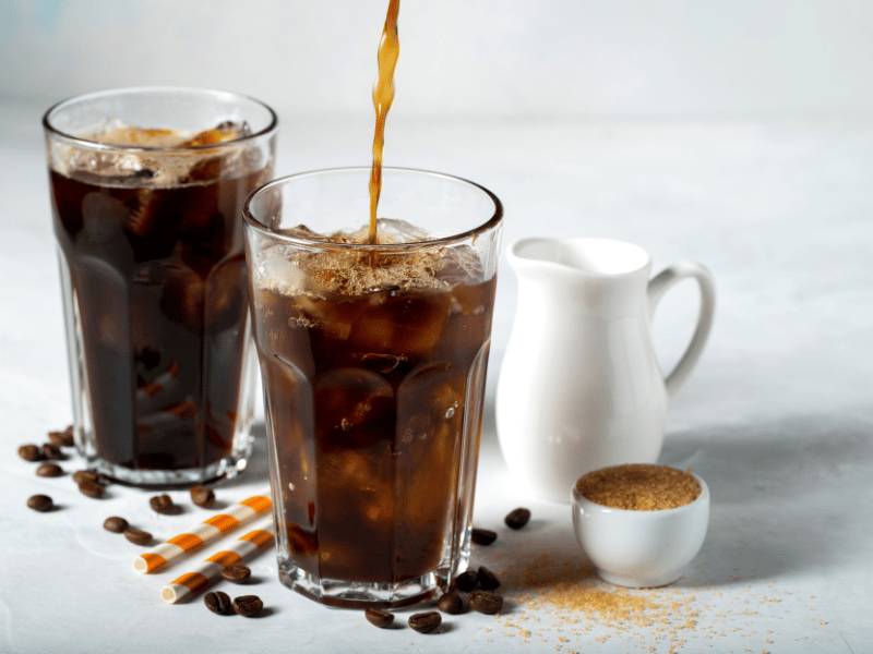image of coffee being poured into a glass filled with ice, it's a sign to limit caffeine intake
