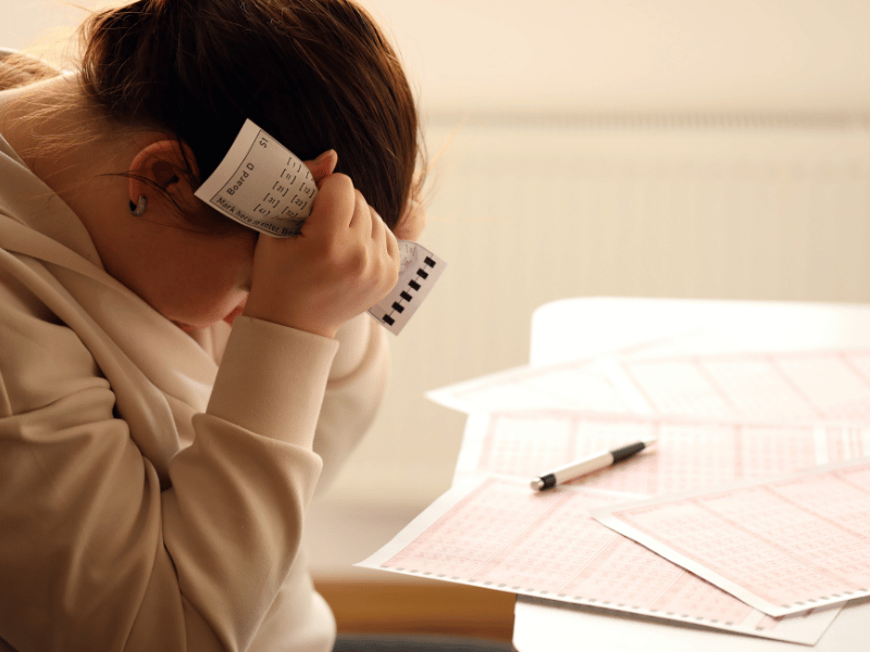 woman holding her head in frustration and sadness over losing lottery ticket