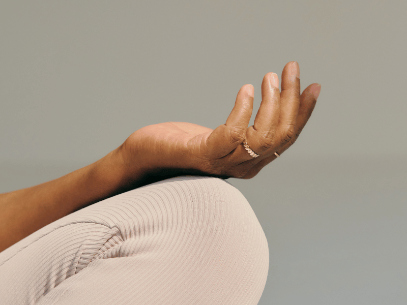 hands placed against the top of the thigh with palms facing up, depicting meditation as a relaxation technique